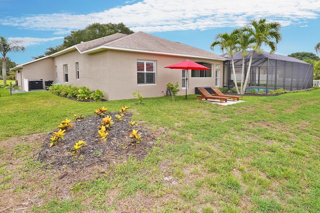 back of property featuring glass enclosure, central AC unit, and a lawn