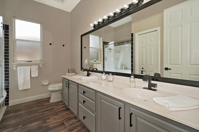 bathroom with hardwood / wood-style flooring, vanity, toilet, and walk in shower