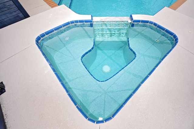 view of pool featuring an in ground hot tub