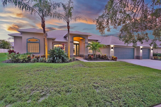 view of front of house with a garage and a yard