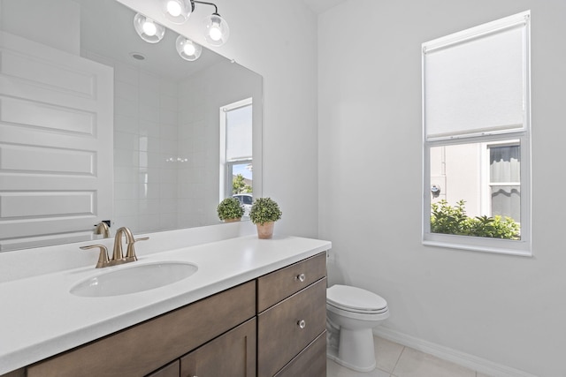 bathroom with toilet, vanity, tile patterned floors, and a wealth of natural light