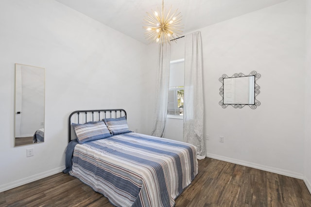 bedroom featuring a notable chandelier and dark wood-type flooring