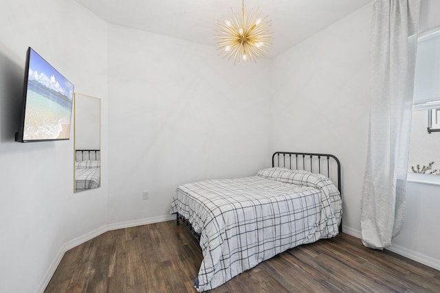 bedroom with dark wood-type flooring and a notable chandelier