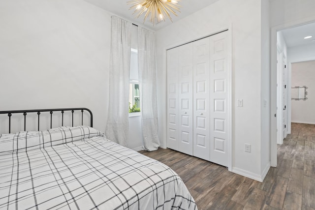 bedroom with a closet, dark hardwood / wood-style floors, and an inviting chandelier