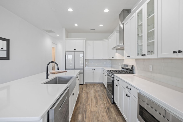 kitchen with backsplash, white cabinets, sink, built in appliances, and dark hardwood / wood-style floors