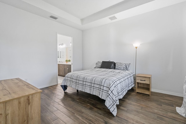 bedroom featuring dark hardwood / wood-style flooring and connected bathroom