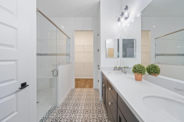 bathroom featuring tile patterned floors, vanity, and a shower with shower door