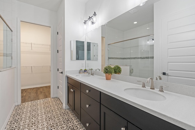 bathroom featuring tile patterned flooring, vanity, and walk in shower