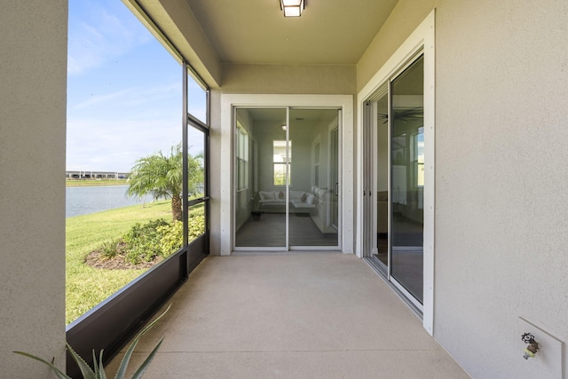 sunroom featuring a water view