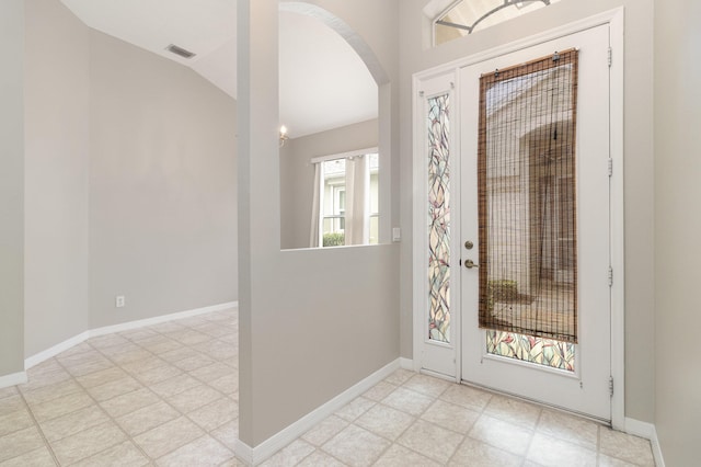 tiled foyer entrance featuring a healthy amount of sunlight and vaulted ceiling