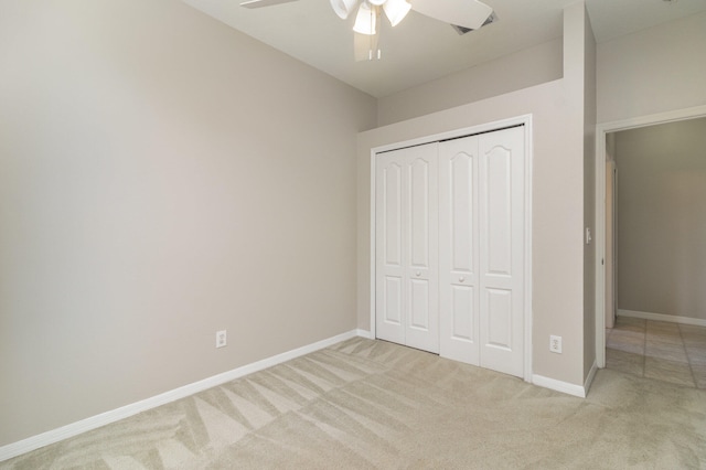 unfurnished bedroom with light carpet, a closet, and ceiling fan