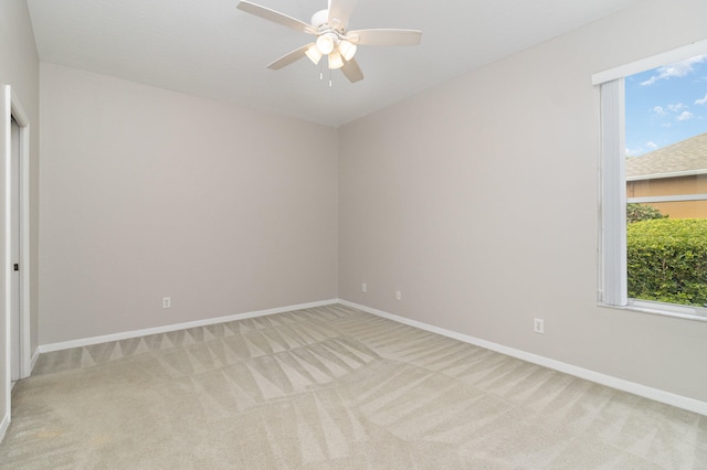 carpeted spare room with ceiling fan