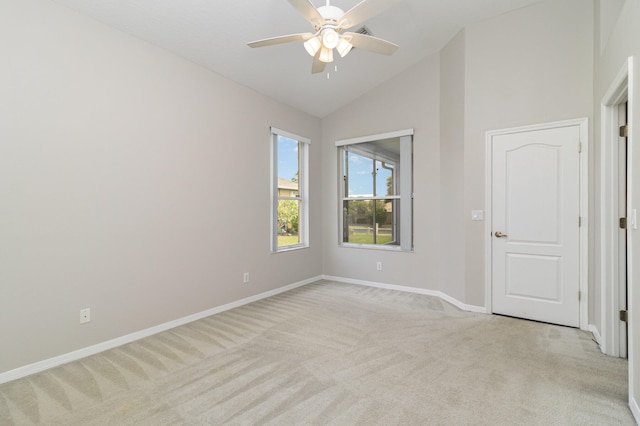 carpeted spare room featuring vaulted ceiling and ceiling fan