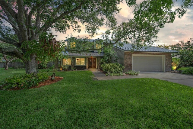 ranch-style home featuring a garage and a lawn