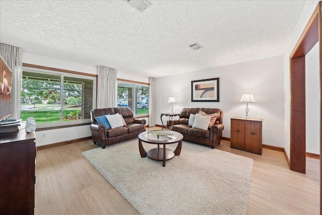 living room featuring light hardwood / wood-style floors and a textured ceiling