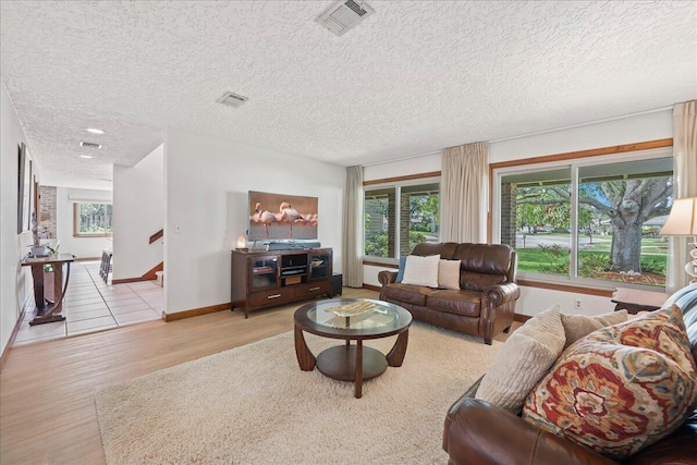 living room featuring a textured ceiling and light hardwood / wood-style floors