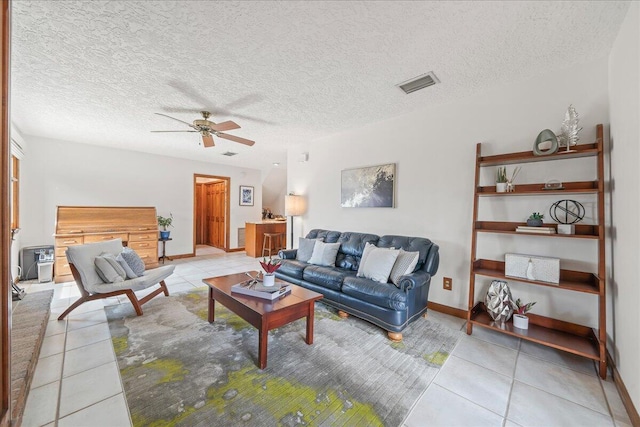 tiled living room featuring a textured ceiling and ceiling fan