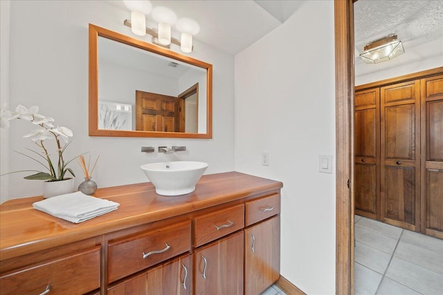 bathroom featuring tile patterned floors, vanity, and a textured ceiling