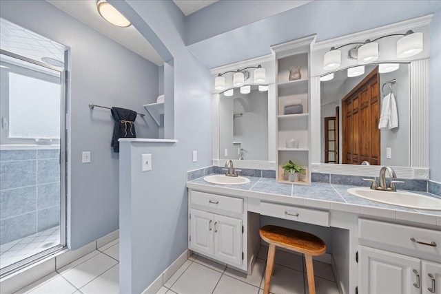 bathroom with tile patterned flooring, vanity, and a shower with door