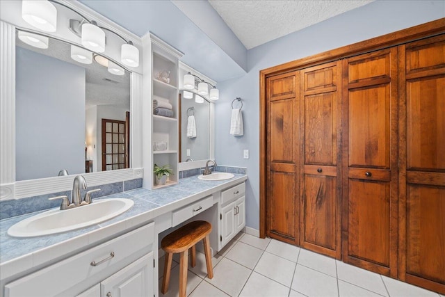 bathroom featuring tile patterned floors, vanity, and a textured ceiling