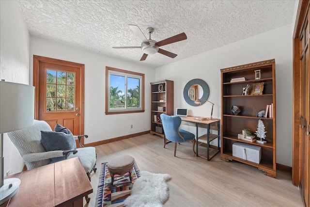 office area featuring ceiling fan, light hardwood / wood-style floors, and a textured ceiling