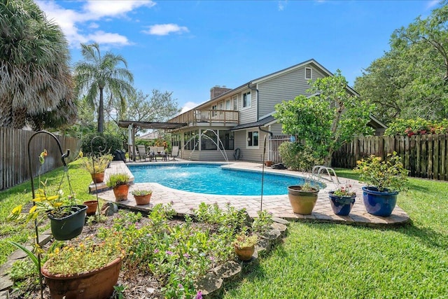 view of swimming pool with pool water feature, a yard, and a patio