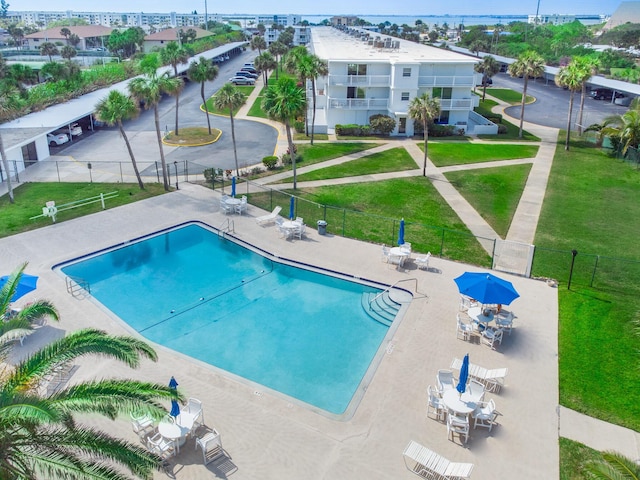 view of pool with a lawn and a patio