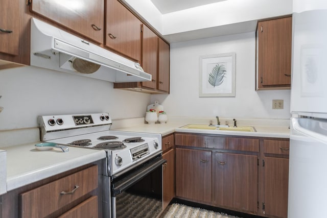 kitchen with range with electric cooktop, white refrigerator, and sink