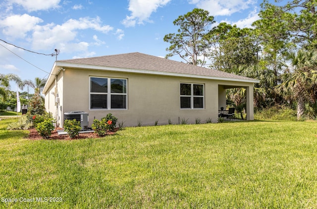 view of side of property featuring a lawn and central AC unit