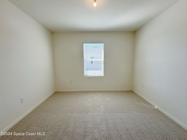 carpeted spare room with a textured ceiling