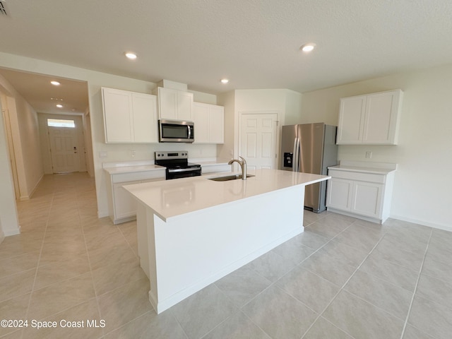 kitchen with white cabinets, sink, stainless steel appliances, and a kitchen island with sink