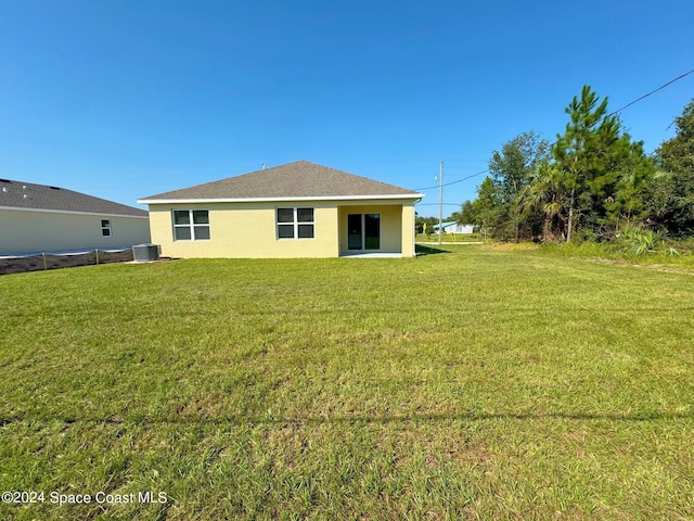 back of house with a yard and central AC unit