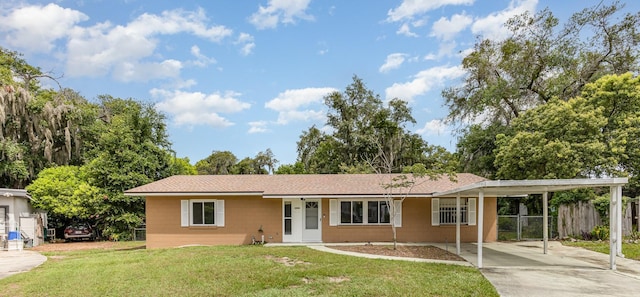 ranch-style house featuring a carport and a front lawn