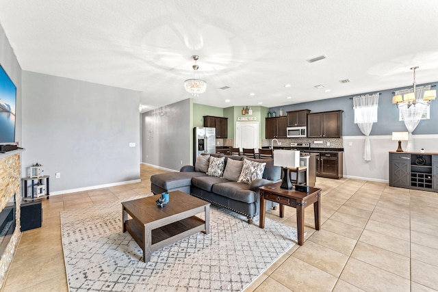 tiled living room featuring a textured ceiling and an inviting chandelier