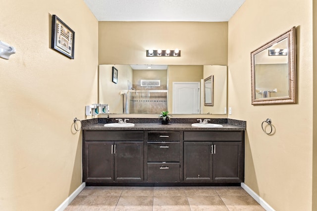 bathroom with vanity, a textured ceiling, tile patterned floors, and a shower with shower door