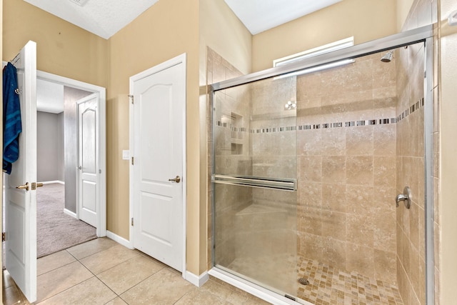 bathroom featuring a shower with door and tile patterned floors