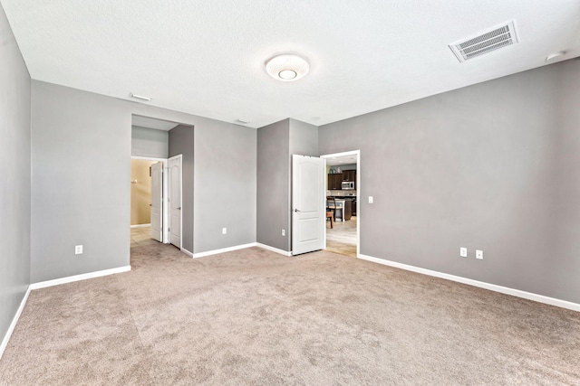 carpeted spare room featuring a textured ceiling