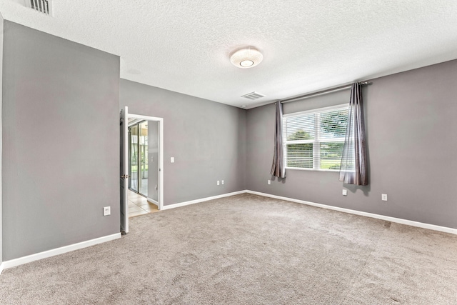 carpeted spare room with a textured ceiling