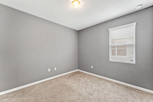 carpeted empty room with a textured ceiling