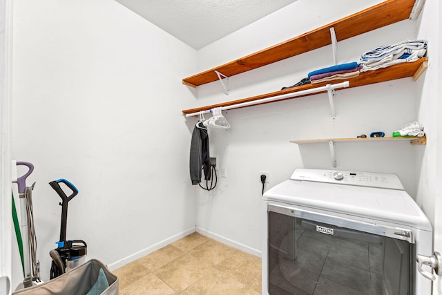 laundry area with washer / clothes dryer and a textured ceiling