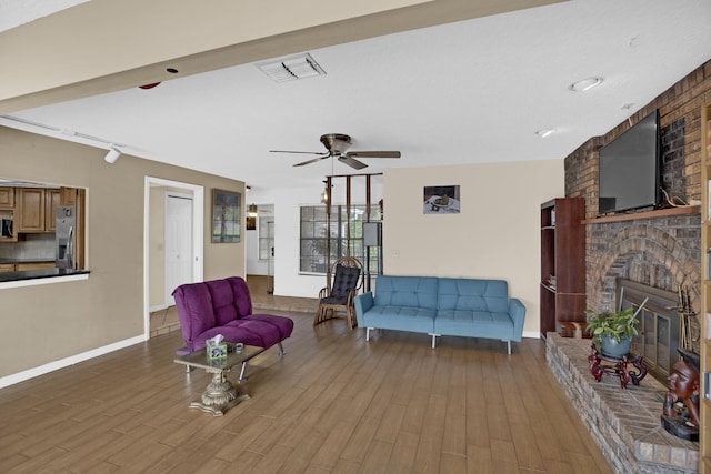 living room with a brick fireplace, wood-type flooring, and ceiling fan