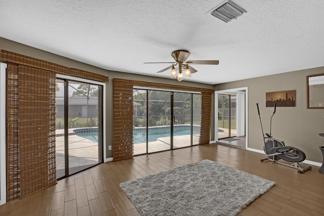 interior space with ceiling fan, dark hardwood / wood-style flooring, and a textured ceiling