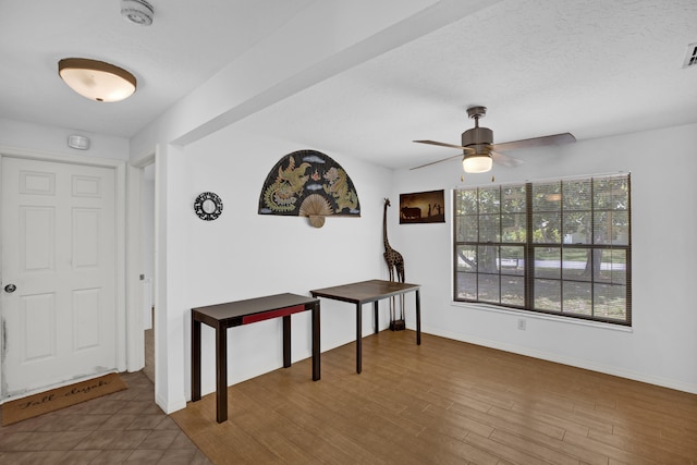 foyer with a textured ceiling, dark wood-type flooring, and ceiling fan