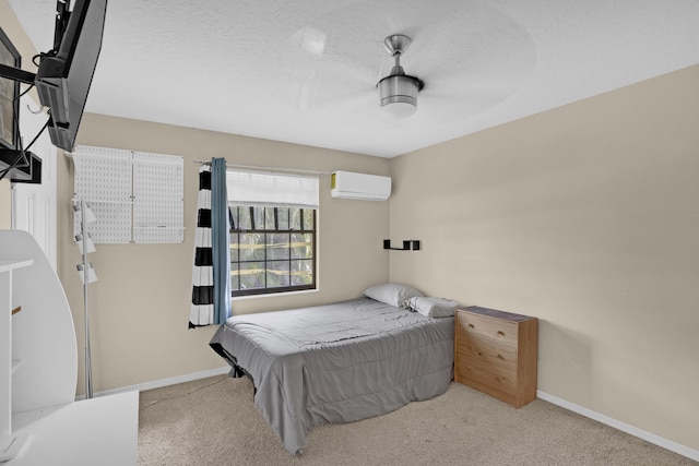 carpeted bedroom featuring a wall unit AC and a textured ceiling