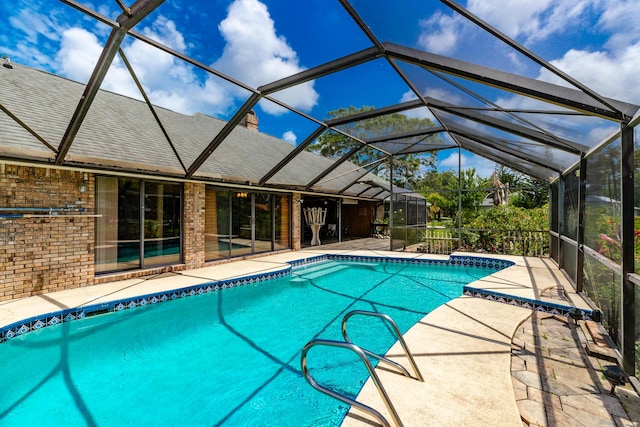 view of swimming pool featuring a patio area and glass enclosure