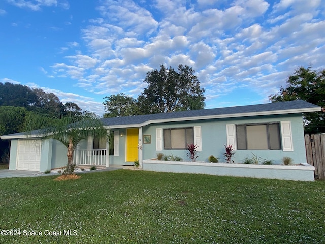 ranch-style home with a front yard, a porch, and a garage