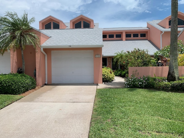 view of front of property with a garage and a front lawn