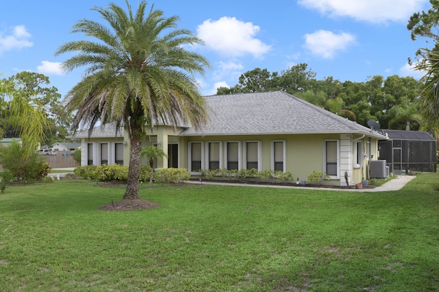 view of front of property featuring a lanai, cooling unit, and a front lawn