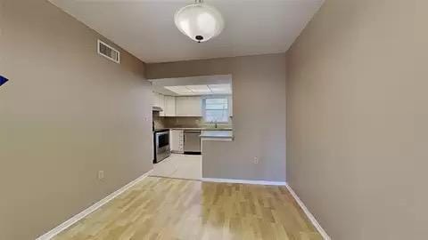 interior space featuring white cabinetry, light hardwood / wood-style flooring, stainless steel dishwasher, and stove