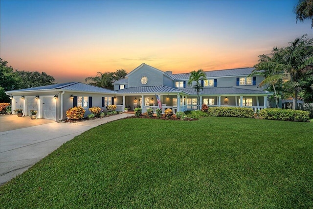 view of front of home featuring a lawn, a porch, and a garage